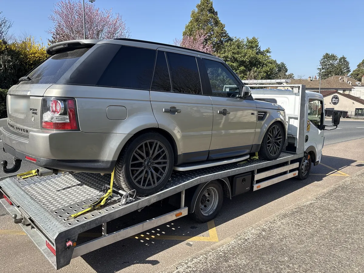 Range Rover chargé et sanglé sur le plateau de la dépanneuse Passe-Partout